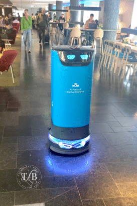 AI-powered cleaning robot moves through KLM Crown Lounge at Amsterdam Airport, enhancing the luxury lounge experience with innovative tech, ensuring a spotless environment for travelers enjoying upscale seating and lounge dining options.