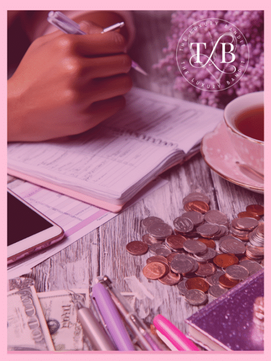 A person actively tracking finances in a notebook, surrounded by coins, cash, a phone, and a cup of tea, with The Luxury Bandit logo. This visual emphasizes diligent credit card debt management and exploring various debt payoff methods to achieve financial freedom debt through strategic planning.